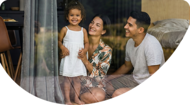 Familia sonriendo junto a una ventana