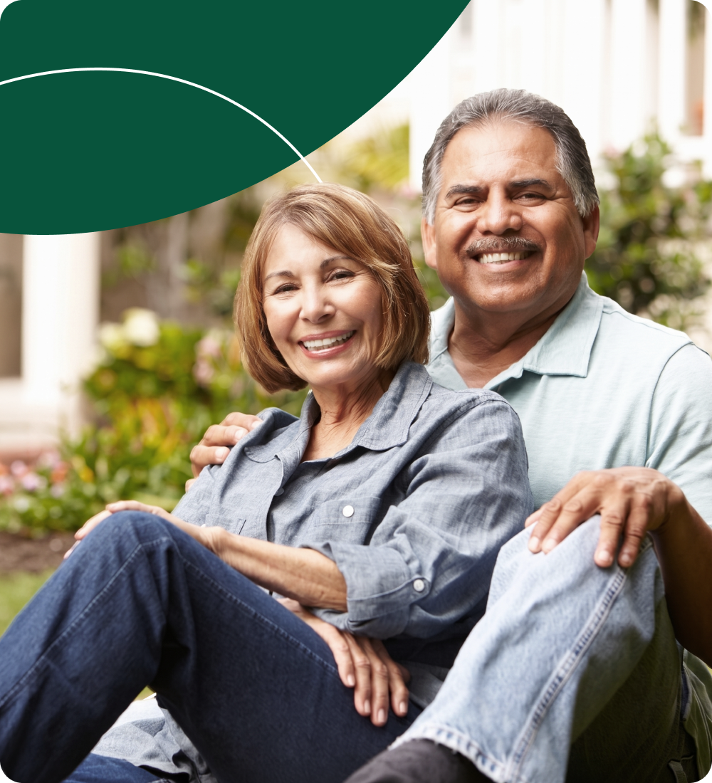 Pareja de adultos mayores sonriendo en un jardín
